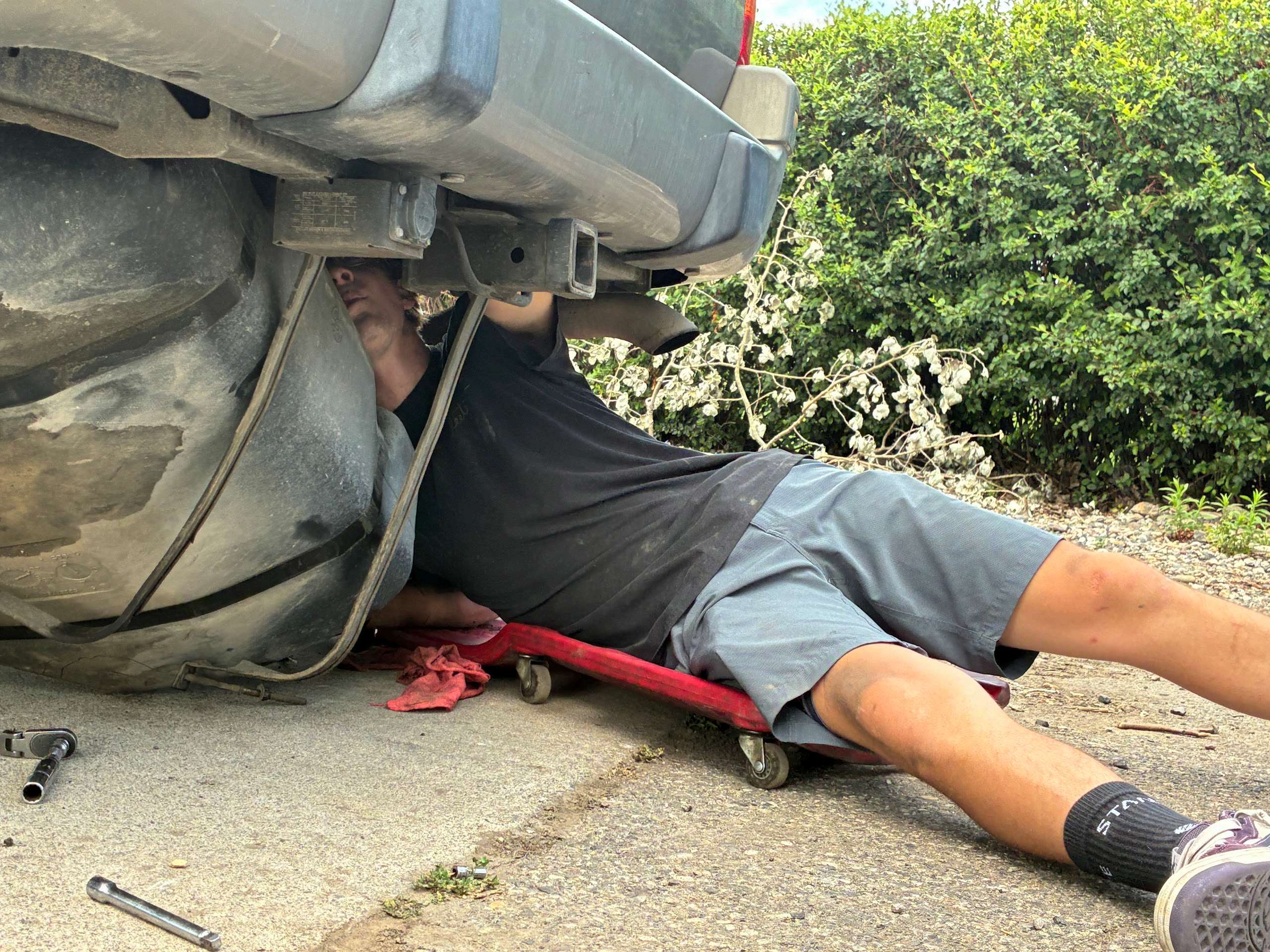Hardline Automotive mechanic working under a vehicle on-site in Montana